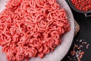 Fresh raw ground beef with salt and spices photo