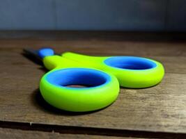 green handled scissors on a wooden table photo