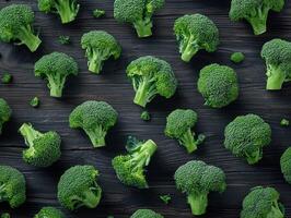 Fresh green broccoli arranged on a dark wooden surface photo