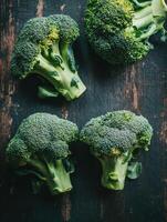 Fresh broccoli stalks on a wooden table, ready for cooking or eating photo