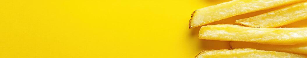 Freshly cooked French fries on a vibrant yellow background photo