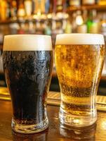 Two glasses of dark and light beer on a wooden bar counter photo