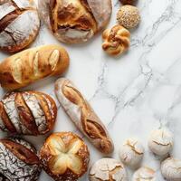 Freshly baked bread varieties on a marble surface with empty space photo