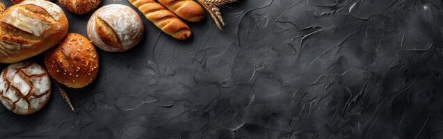 Freshly baked variety of artisan bread on dark textured surface photo