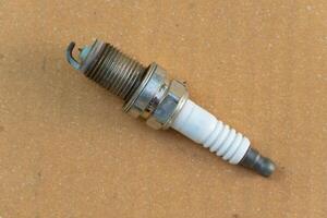 Used single spark plugs. The spark plugs are extremely old. On the stained brown paper. photo