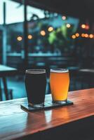 Two glasses of dark and light beer on a bar counter at dusk photo