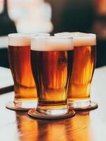 Beer mugs filled with golden beverage on wooden table in cozy bar photo
