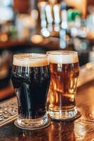 Two glasses of dark and light beer on a bar counter in a pub photo