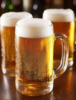Beer mugs with foam on a wooden bar table during happy hour photo