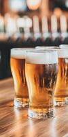 Frothy beer mugs on a wooden table at a lively bar photo