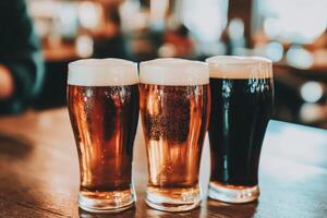 Beer mugs with foam on a wooden table in a lively bar setting photo