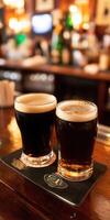 Two glasses of dark and light beer on a bar counter in a pub photo