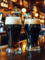 Two glasses of dark and light beer on a wooden bar counter photo