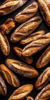 Freshly baked bread loaves arranged on a black surface photo