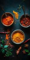 Colorful Indian spices displayed in bowls with herbs and dried peppers photo