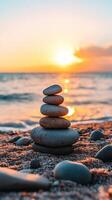 Stacked zen stones on a beach at sunset photo