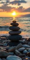Zen stones balanced by the shoreline at sunset photo