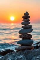 Balanced zen stones at sunset by the ocean shore photo
