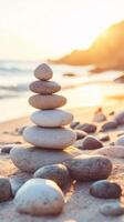 Stacked zen stones at sunset on a tranquil beach photo