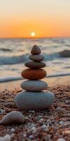 Balanced zen stones at sunset by the ocean shore photo