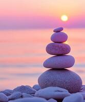 Balanced zen stones at sunset on a tranquil shoreline photo