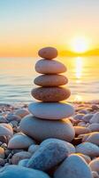 Balanced zen stones stacked on a tranquil beach at sunset photo