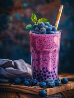 Boba milk tea topped with fresh blueberries and mint leaves photo
