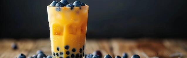 Boba milk tea topped with fresh blueberries on a wooden table photo