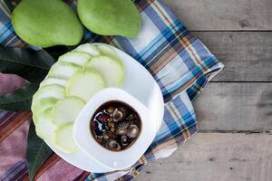 Top view of Sliced Mangoes with sweet fish sauce is a favorite of Thai people. photo