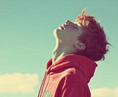 High school boy gazing at the blue sky during a sunny day photo