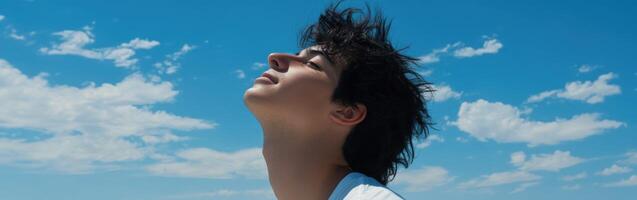 High school boy gazing at a clear sky on a sunny day photo