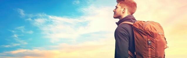 High school boy gazing at the sky during sunset with backpack photo