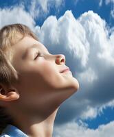 High school boy gazing up at the cloudy sky during a sunny day photo