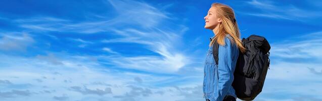 High school girl gazing at the sky with a backpack on a sunny day photo