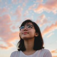 High school girl gazing at the colorful sky during sunset photo