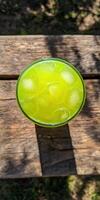Refreshing green mint lemonade served over ice in a sunny outdoor setting photo
