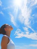 High school girl looking up at a clear blue sky during the day photo
