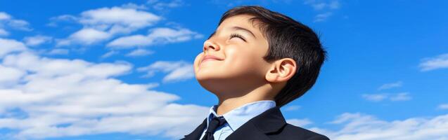 High school boy gazing up at a clear blue sky on a sunny day photo