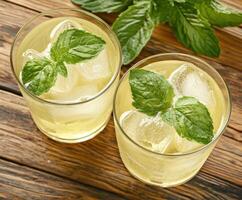 Refreshing green mint lemonade with ice served in glasses photo