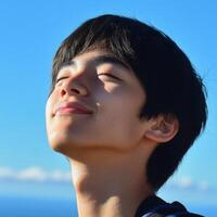 High school boy looking up at the clear blue sky during daylight photo