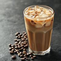 Iced coffee with cream served in a tall glass on a dark surface photo