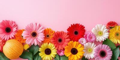 Autumn flowers and pumpkins arranged on a soft pink background photo
