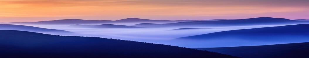 Fog envelops mountains at twilight, showcasing layered silhouettes photo