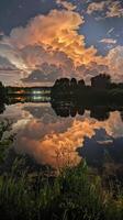Night clouds illuminating a tranquil lake at twilight photo