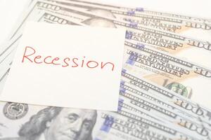Hand writing Recession on paper note. Global economic crisis. Recession business and stock crisis concept. photo