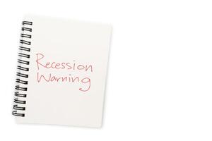 Hand writing Recession Warning on notebook. Global economic crisis. Recession business and stock crisis concept. photo