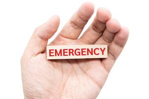 Text EMERGENCY wooden block on hand. Financial and business concept. retirement saving concept. money saving for rainy day. isolated on white background and clipping path. photo