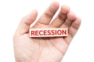 Text RECESSION wooden block on hand. Financial and business concept. isolated on white background and clipping path. Global economic crisis. Recession business and stock crisis concept. photo