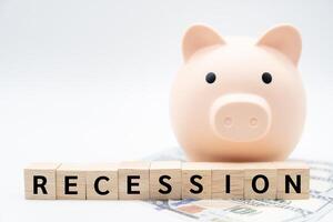 Wooden blocks with RECESSION wording and Piggy bank. Business and education concept. Copy space. Global economic crisis. Recession business and stock crisis concept. photo