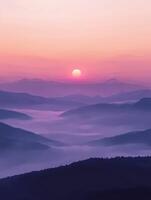 Foggy evening mountains with sunset glow over low valleys photo